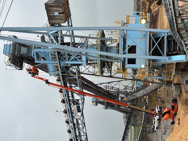 A crane is being used to lift a large piece of metal.